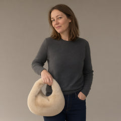 Woman wearing the faux fur dumpling bag, top handle, full length, studio