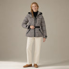 Woman wearing the belted hooded ski jacket, padded zip-front, full length, studio