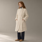 Woman wearing the belted mandarin collar wool coat, three-quarter view, studio