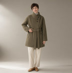 Woman wearing the belted stand-collar wool coat, full length, studio