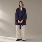 Woman wearing the belted wrap wool coat, fringed hem, full length, studio
