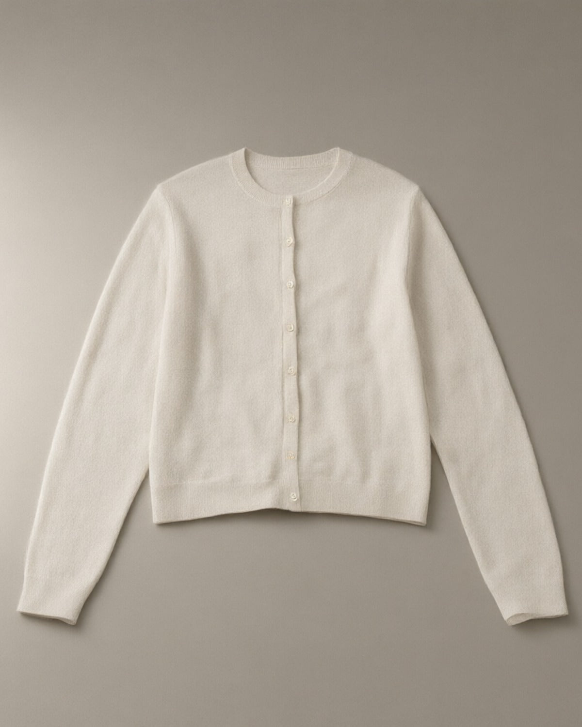 Women’s Button-Front Knit Cardigan, laid flat on a stone backdrop