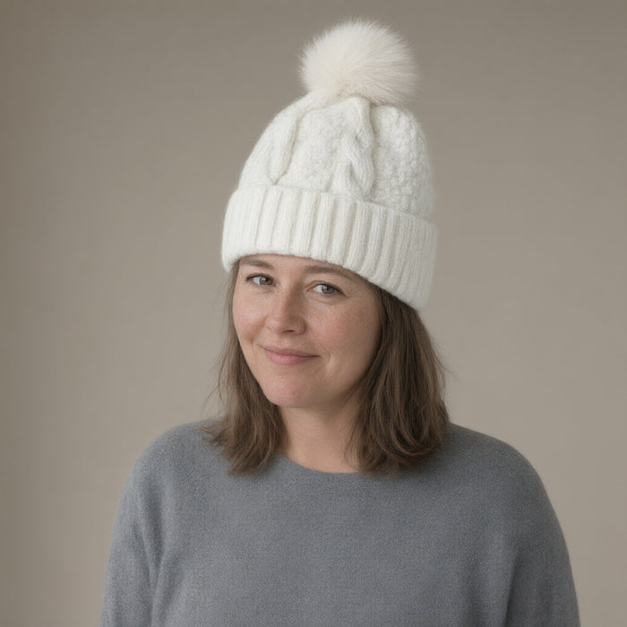 Woman wearing the cable knit bobble hat, faux fur pompom, full length, studio