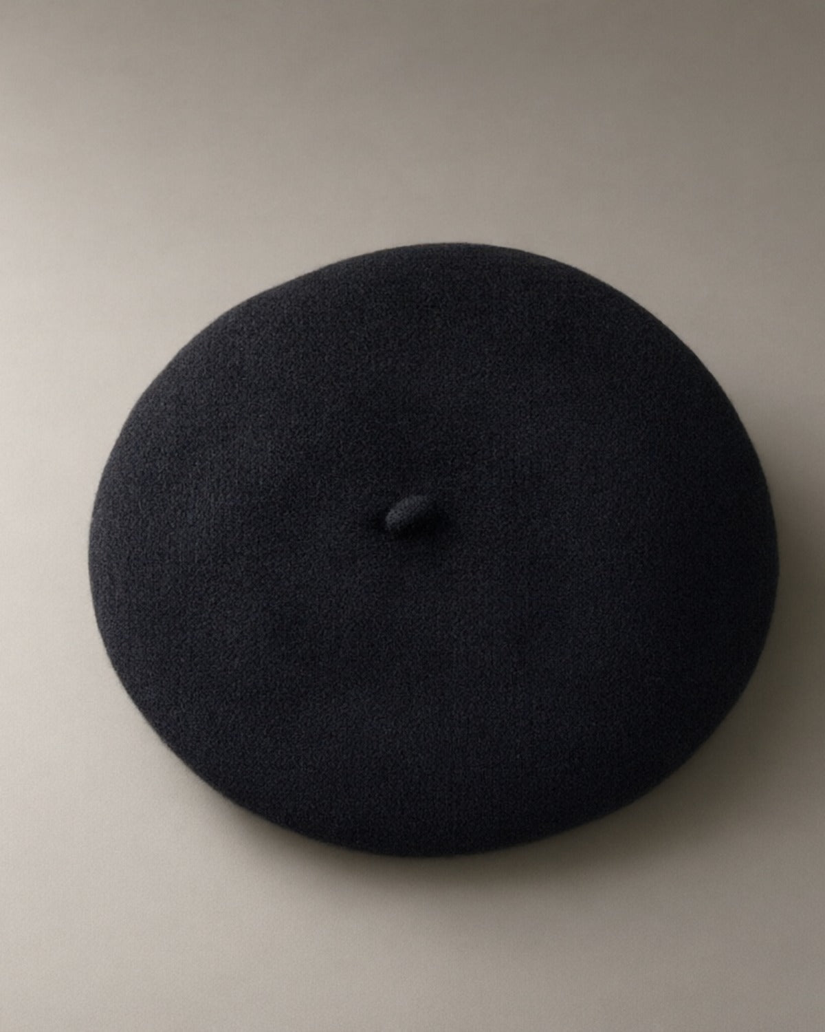 Women’s Classic Wool Beret, Knitted, laid flat on a stone backdrop