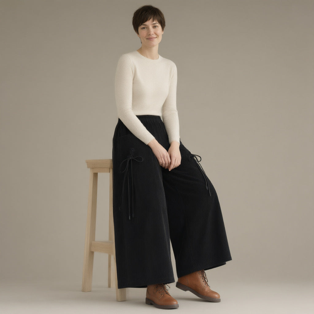 Woman wearing the wide-leg corduroy culottes, elastic waist, three-quarter view, studio