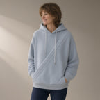 Woman wearing the fleece hoodie, cross-front pocket, three-quarter view, studio