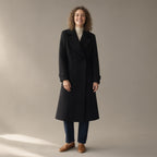 Woman wearing the long double-breasted coat, tailored collar – black, full length, studio
