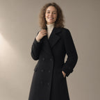 Woman wearing the long double-breasted coat, tailored collar – black, three-quarter view, studio