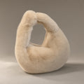 Women’s Faux Fur Dumpling Bag, Top Handle, laid flat on a stone backdrop