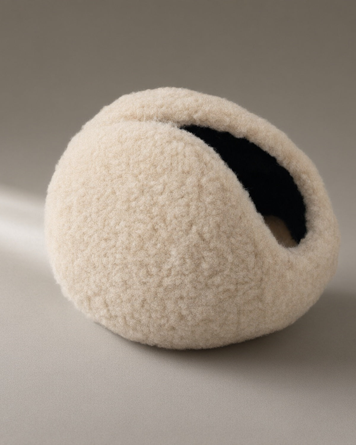 Women’s Windproof Fleece Earmuffs, Folding Band, laid flat on a stone backdrop