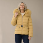 Woman wearing the faux fur trim hooded puffer jacket, belted, three-quarter view, studio