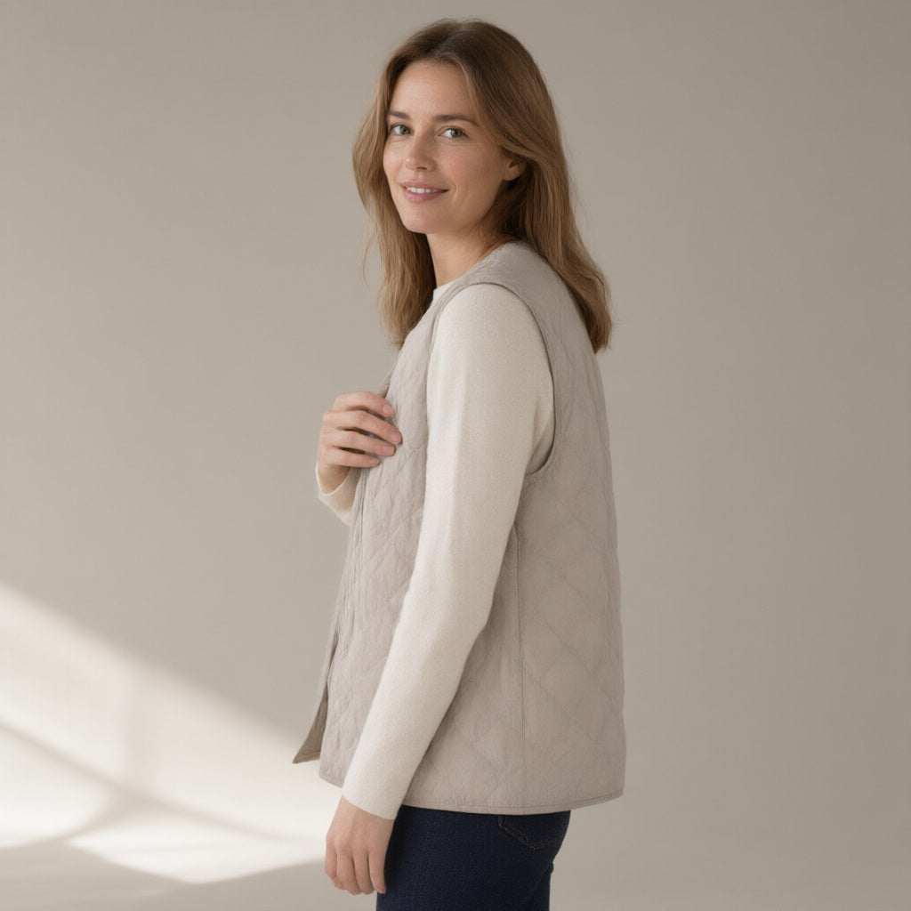 Woman wearing a stone quilted gilet over a cream knit, three-quarter turn