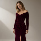 Woman wearing a wine velvet off-shoulder mermaid gown, three-quarter turn