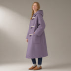 Woman wearing the hooded duffle coat, toggle fasten, double-faced wool blend, three-quarter view, studio