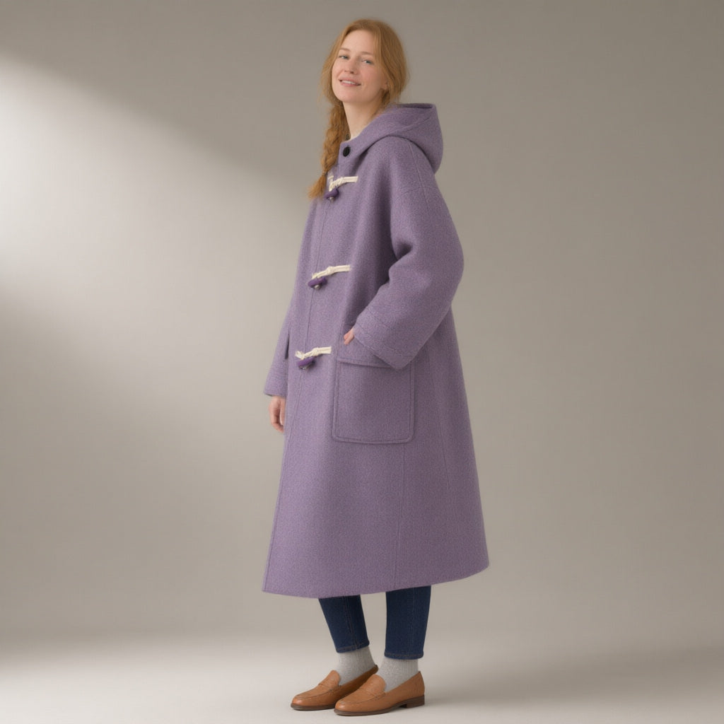 Woman wearing the hooded duffle coat, toggle fasten, double-faced wool blend, three-quarter view, studio