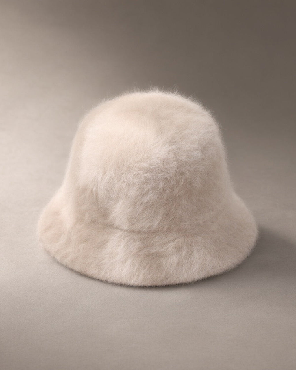 Women’s Knit Fluffy Bucket Hat, laid flat on a stone backdrop