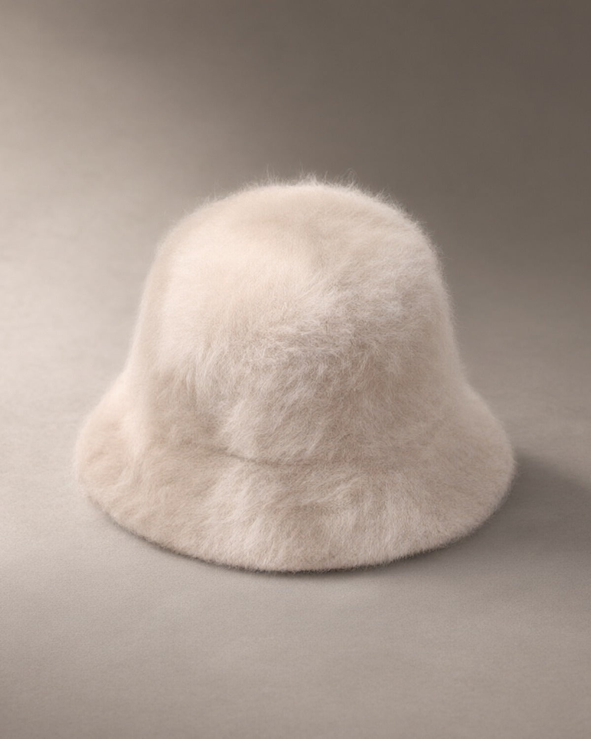 Women’s Knit Fluffy Bucket Hat, laid flat on a stone backdrop