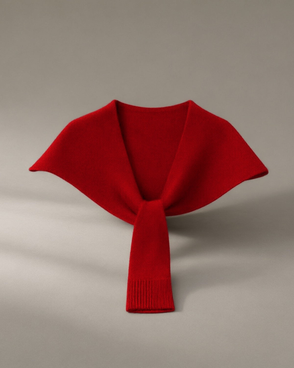 Women’s Knitted Pull-Through Collar Wrap, laid flat on a stone backdrop