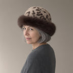 Woman wearing the faux fur trapper hat, leopard print, three-quarter view, studio