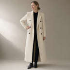 Woman wearing the long double-breasted wool coat, wide lapel, full length, studio