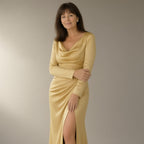 Woman wearing the long-sleeve satin prom dress, wrap slit – gold, three-quarter view, studio