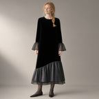 Woman wearing the mesh hem velvet midi dress, flared sleeve – black, three-quarter view, studio