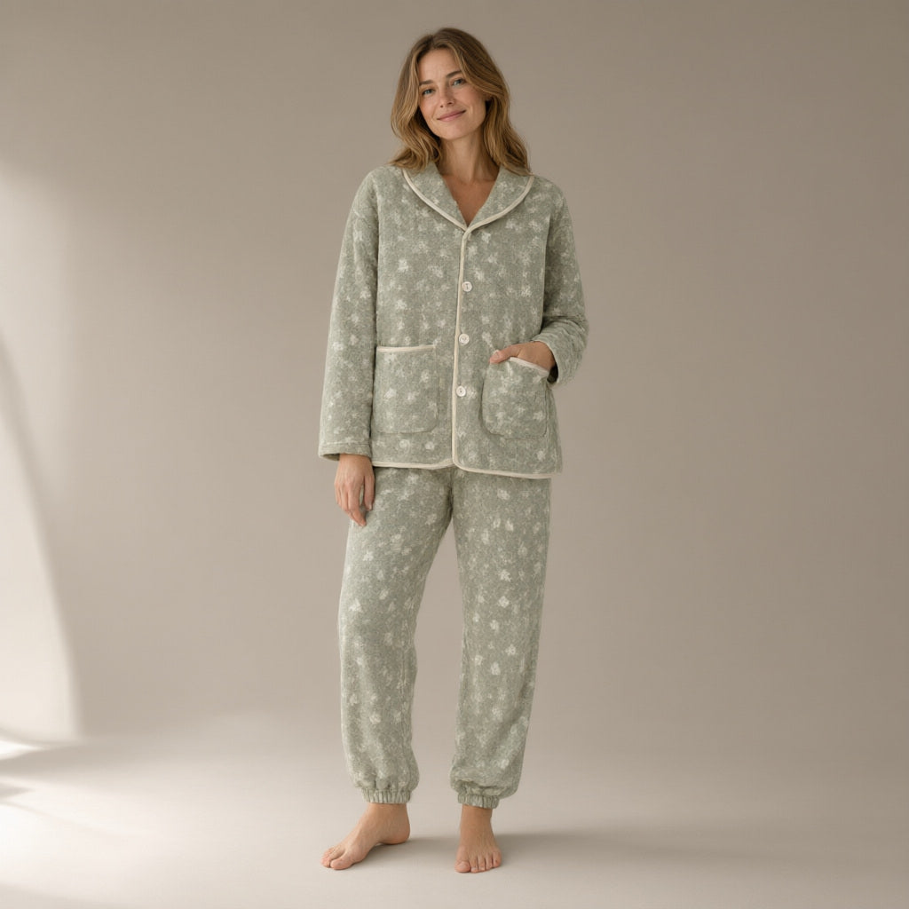 Woman wearing a sage green floral flannel fleece pyjama set, full length, one hand in the pocket
