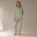 Woman wearing a sage green floral flannel fleece pyjama set, full length, one hand in the pocket