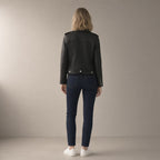 Woman seen from behind wearing the pu biker jacket, short zip-front – black, back view