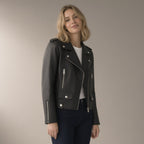 Woman wearing the pu biker jacket, short zip-front – black, three-quarter view, studio