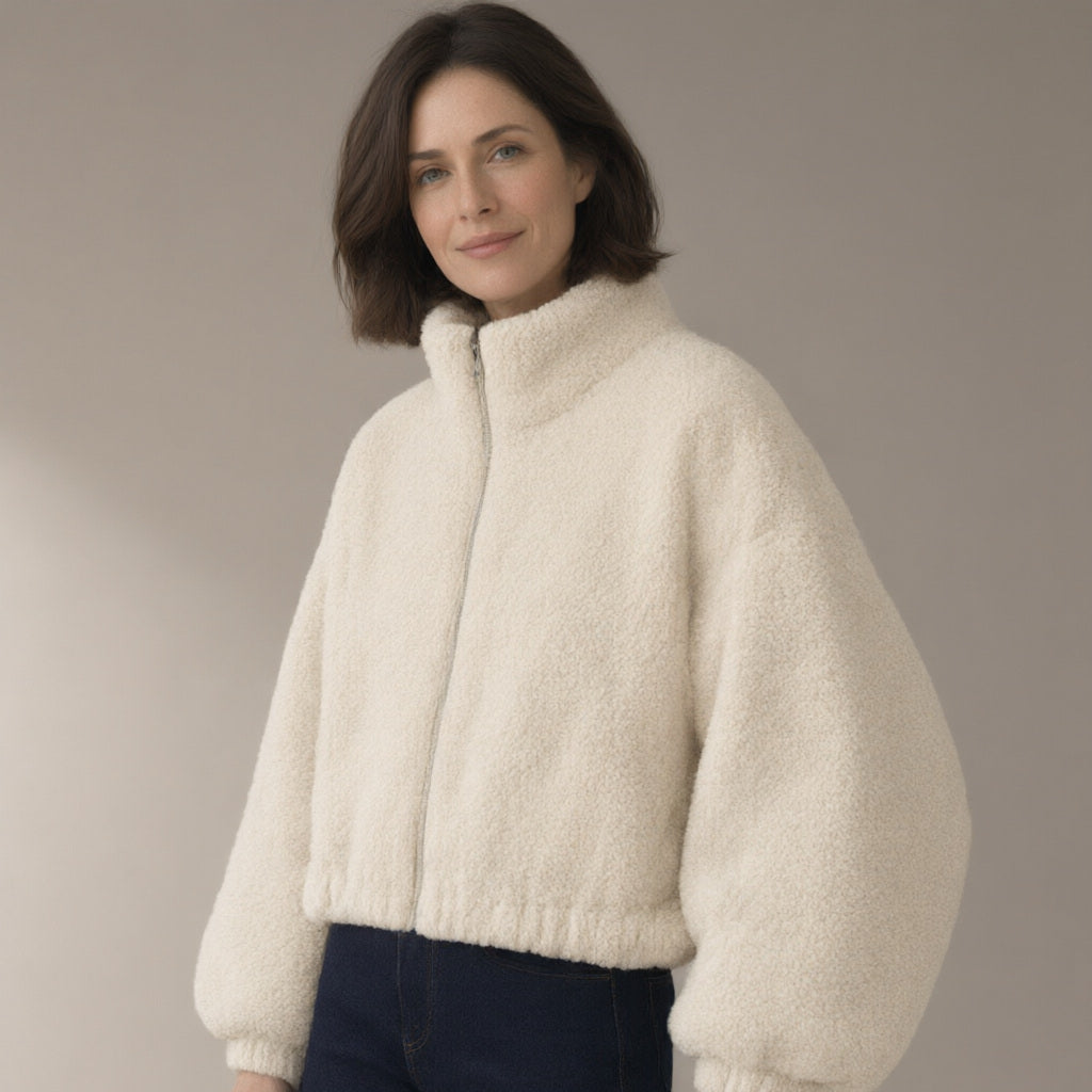 Woman wearing the teddy fleece jacket, zip stand collar, three-quarter view, studio