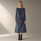 Woman wearing the twist-waist velvet evening dress, long sleeve – slate grey, full length, studio