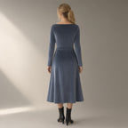 Woman seen from behind wearing the twist-waist velvet evening dress, long sleeve – slate grey, back view