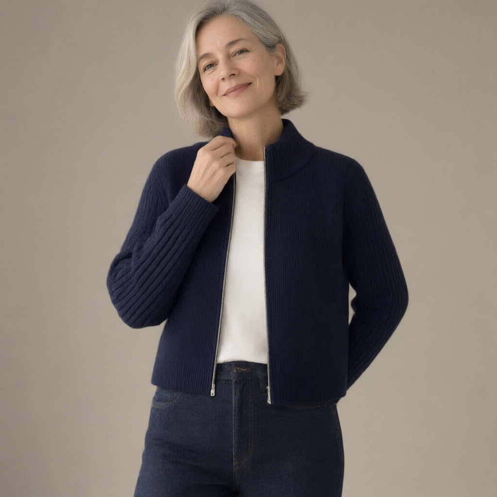Woman wearing the zip-up ribbed knit cardigan, stand collar – navy, three-quarter view, studio